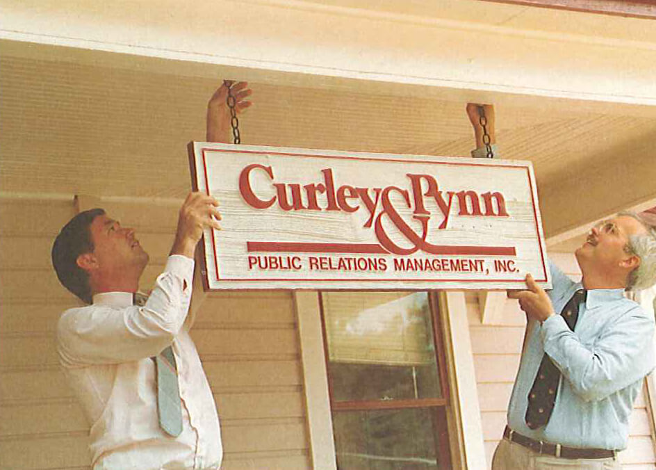 1984 - Joe Curley APR, CPRC, and Roger Pynn APR, CPRC, hang sign for new Curley & Pynn Public Relations Management, Orlando’s first public relations agency.