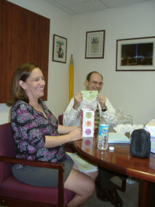 Rae and Dan Ward open gifts at an office baby shower